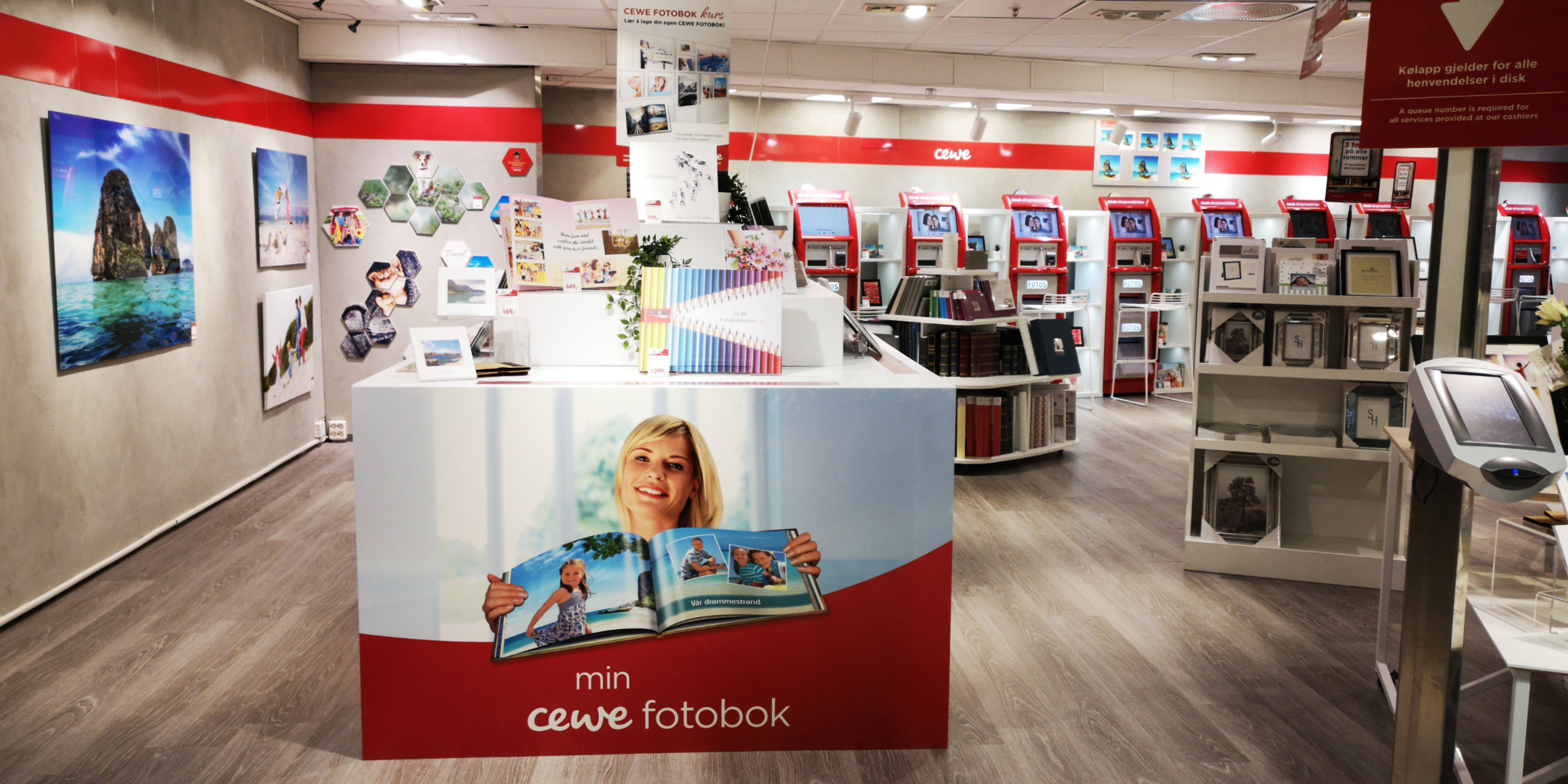 En lys og innbydende butikk med CEWE-produkter, inkludert fotoalbum, veggdekor og fotoutskrifter.