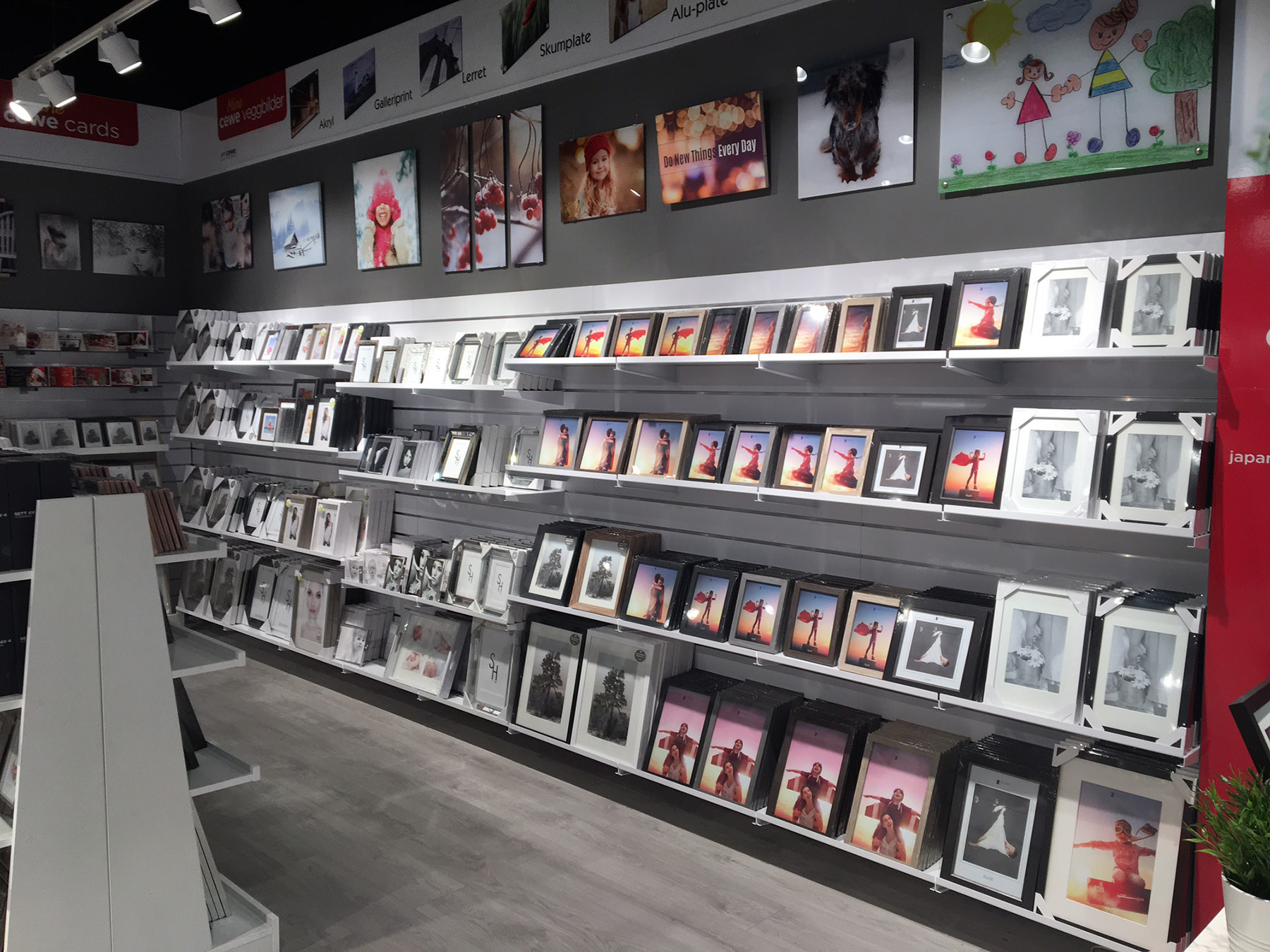 Nettbutikk med vegger fylt av ulike innrammede bilder og kunsttrykk i forskjellige størrelser og stiler