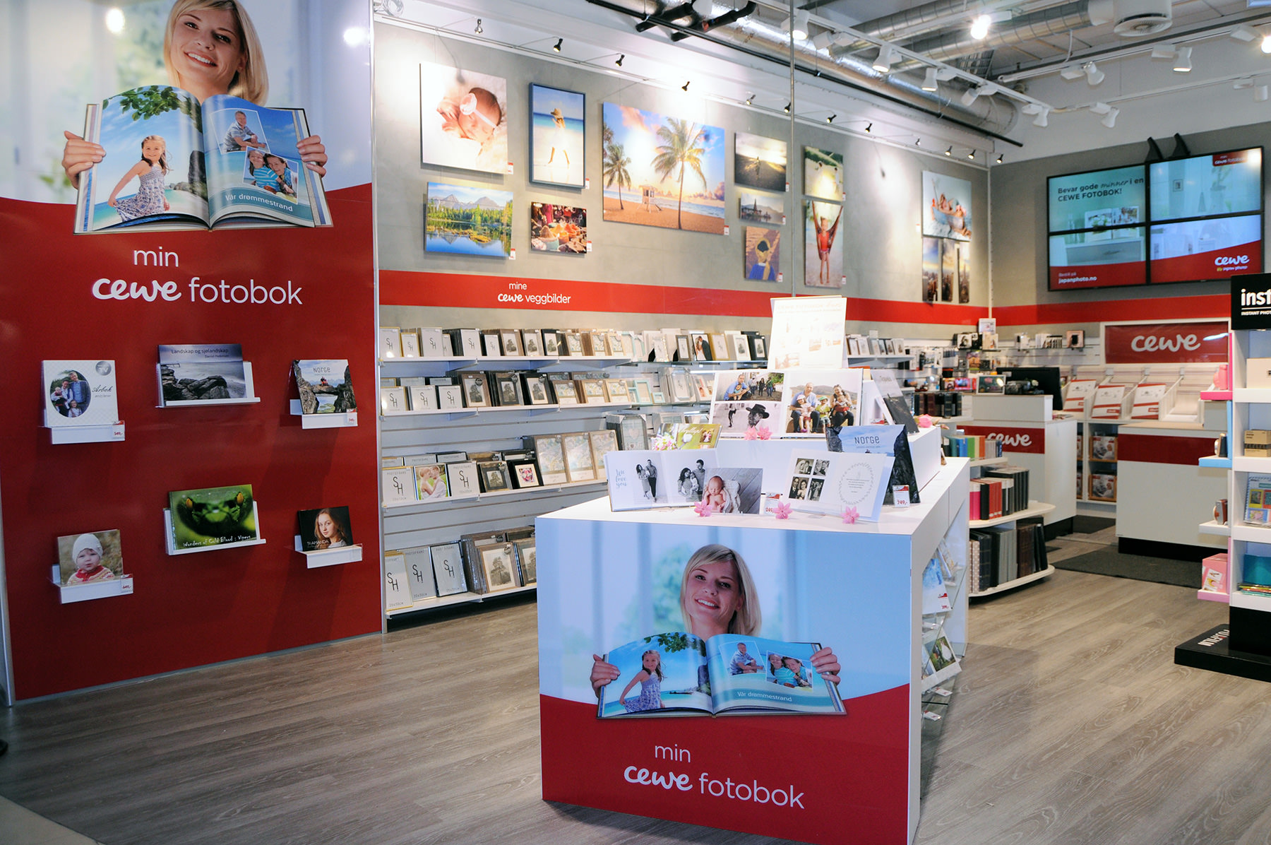 Lyst og innbydende butikkrom med CEWE-produkter, inkludert veggbilder, fotobøker og stående rammer Lyst og innbydende butikkrom med CEWE-produkter, inkludert veggbilder, fotobøker og stående rammer