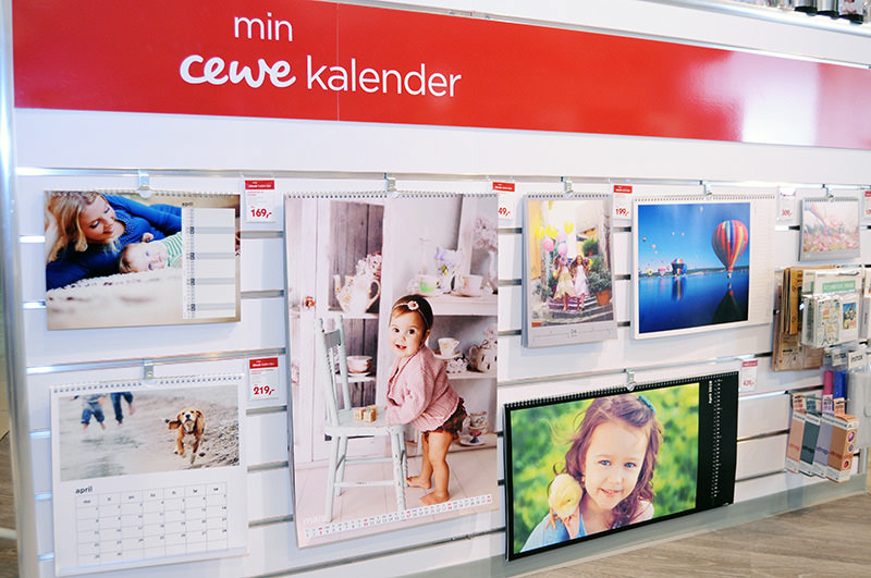 Utstillingsvegg med CEWE-kalendere i ulike design og formater, inkludert bilder av kjæledyr, familier og natur. Utstillingsvegg med CEWE-kalendere i ulike design og formater, inkludert bilder av kjæledyr, familier og natur.