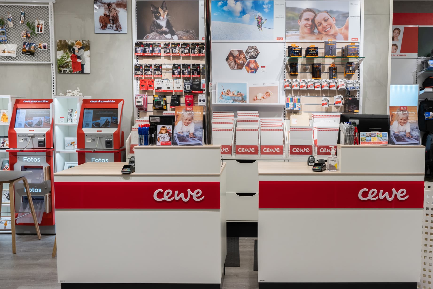 CEWE-butikk med røde og hvite skranker, fotoprintere og hyller med fotoprodukter og tilbehør