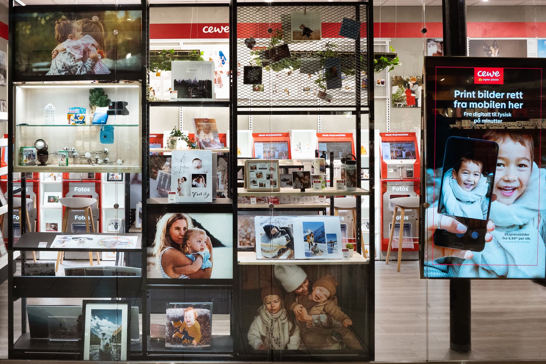 Butikkvindu med utstilte fotoprodukter, inkludert bilderammer, fotobøker og gaveartikler