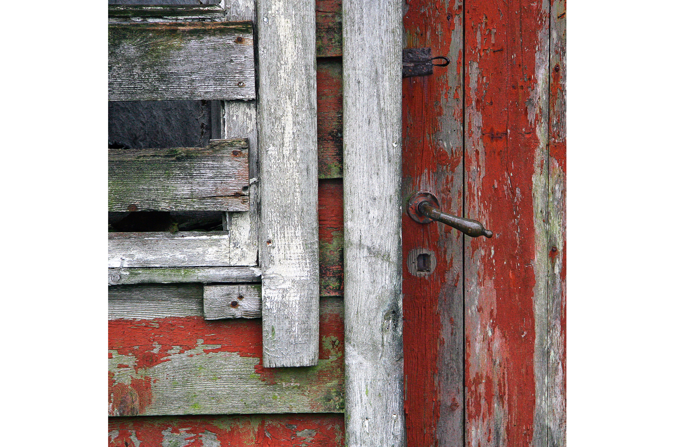 Slitt rød trevegg med del av en gammel dør og rustent dørhåndtak Slitt rød trevegg med del av en gammel dør og rustent dørhåndtak