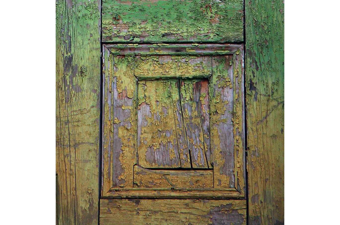 Gammel trefasade med grønn og gul maling som flasser av, viser treets naturlige struktur Gammel trefasade med grønn og gul maling som flasser av, viser treets naturlige struktur