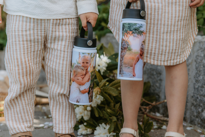 To barn i matchende stripete klær holder personlige drikkeflasker med fotomotiv fra spesielle øyeblikk.