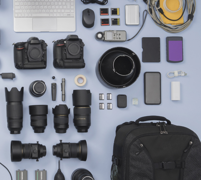 Flatlay av fotoutstyr inkludert kameraer, objektiver, minnekort, ryggsekk, og laptop Flatlay av fotoutstyr inkludert kameraer, objektiver, minnekort, ryggsekk, og laptop