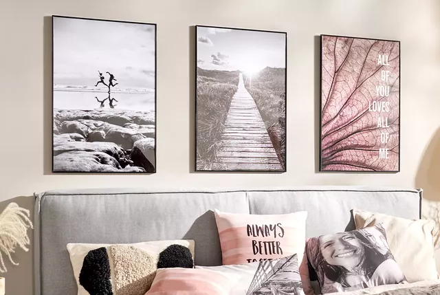 Tre veggbilder over en sofa, med puter i lyse toner og inspirerende sitater