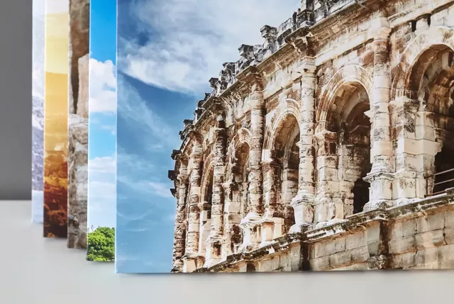 Ruin av en gammel romersk bygning med buer og detaljerte steinstrukturer under en blå himmel med lette skyer