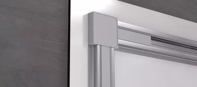 Sølvfarget hjørnedetalj på en moderne aluminiumsramme mot en grå veggbakgrunn