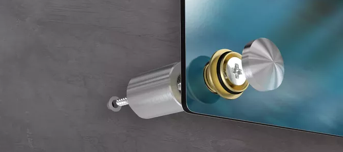 Speilfeste montert på en betongvegg med metallholder og skruer, vist i nærbilde