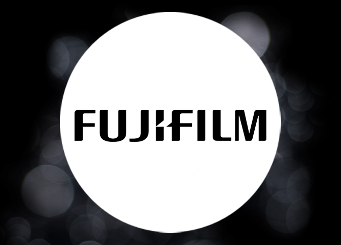 Svart bakgrunn med lysende hvit sirkel i midten og FUJIFILM-logo i svart tekst