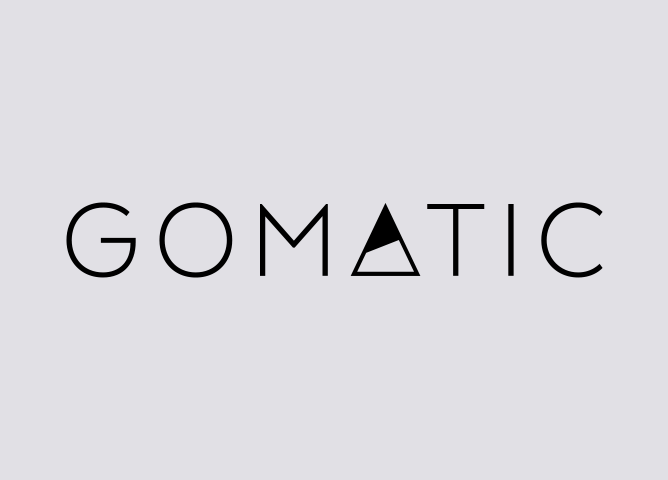Gomatic-logo med minimalistisk sort tekst på grå bakgrunn