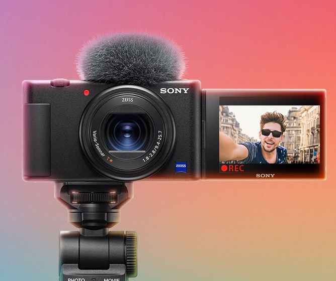 Sony kamera med utfellbar skjerm som viser en gate omgitt av bygninger, montert på et stativ