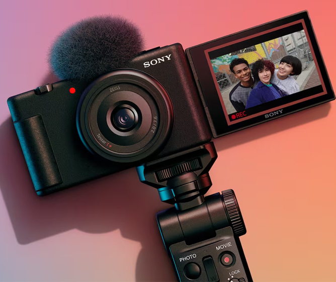 Sony videokamera med mikrofon og vridbart display som viser et bilde av tre personer.