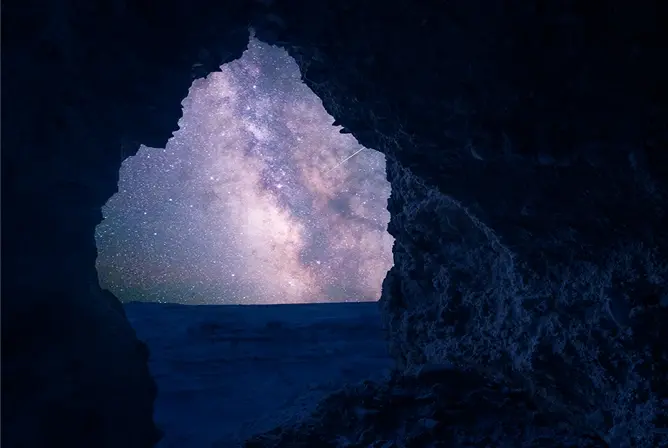 En steinformasjon danner en naturlig ramme rundt en stjerneklar nattehimmel med Melkeveien tydelig synlig