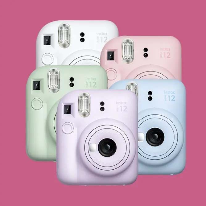 Fem Instax Mini 12-kameraer i pastellfarger, inkludert grønn, hvit, lilla, rosa og blå, på en rosa bakgrunn
