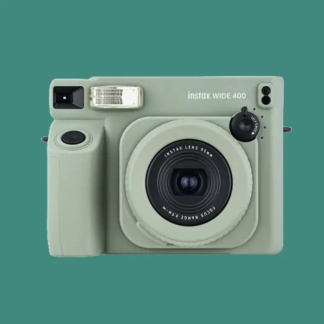 Lysegrønt, retroinspirert instantkamera med stor linse i midten og blits til venstre