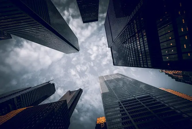 Høye skyskrapere mot en dramatisk himmel med skyer