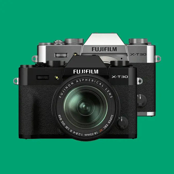 To Fujifilm X-T30 kameraer, én i sort og én i sølv, presentert mot en grønn bakgrunn
