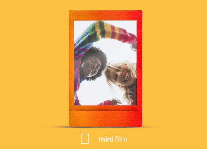 To mennesker i fargerike klær smiler og ser ned, sett fra et lavt perspektiv, innrammet i en polaroidramme