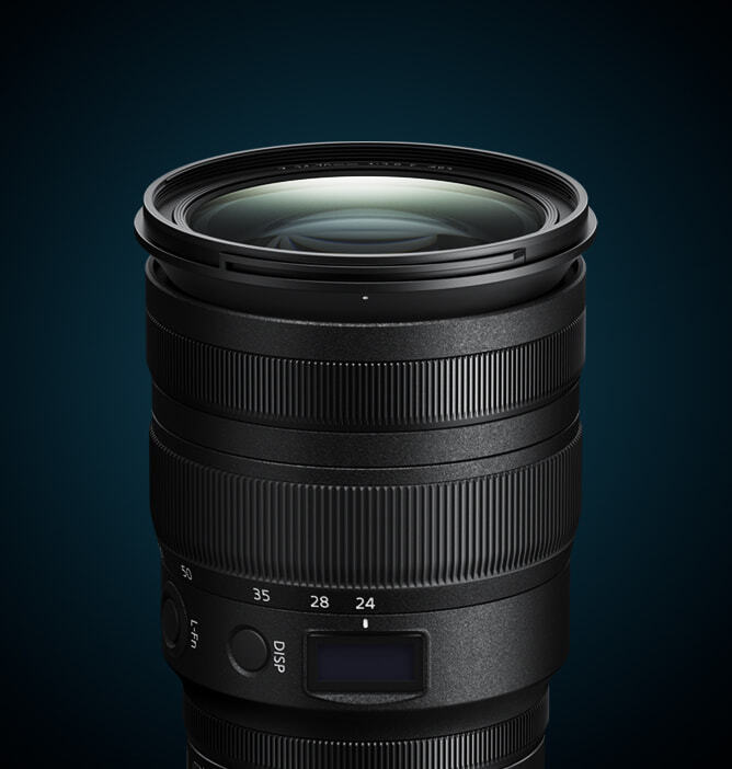 Svart kameralinse med flere justeringsringer og en liten skjerm på siden, mot mørk blå bakgrunn