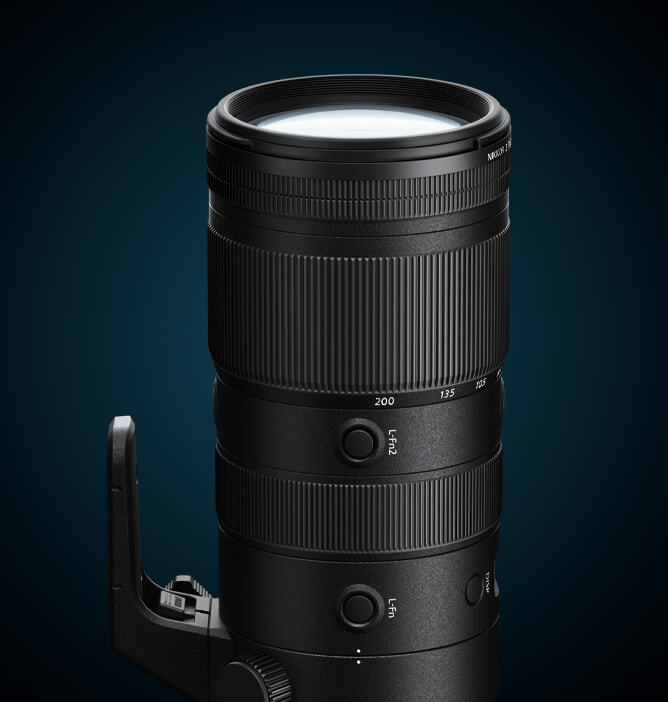 Sort objektiv på mørk blå bakgrunn med zoomring og stativfeste