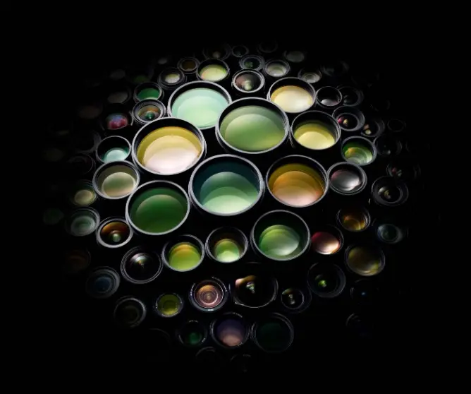 En sirkel av fargerike kameralinser mot svart bakgrunn