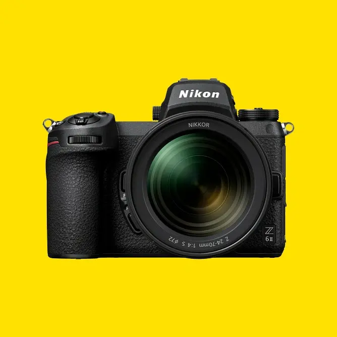 Speilreflekskamera Nikon Z6II med stort objektiv foran en lys gul bakgrunn