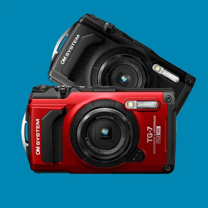 To kameraer fra OM-System, en rød og en svart, plassert delvis overlappende på en blå bakgrunn To kameraer fra OM-System, en rød og en svart, plassert delvis overlappende på en blå bakgrunn