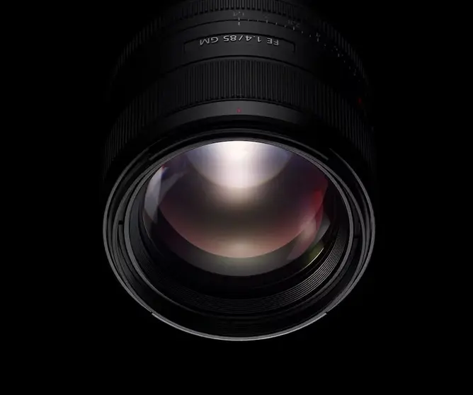 Et kameraobjektiv med bred glasslinse og svart ramme, sett forfra med lysrefleksjoner i glasset