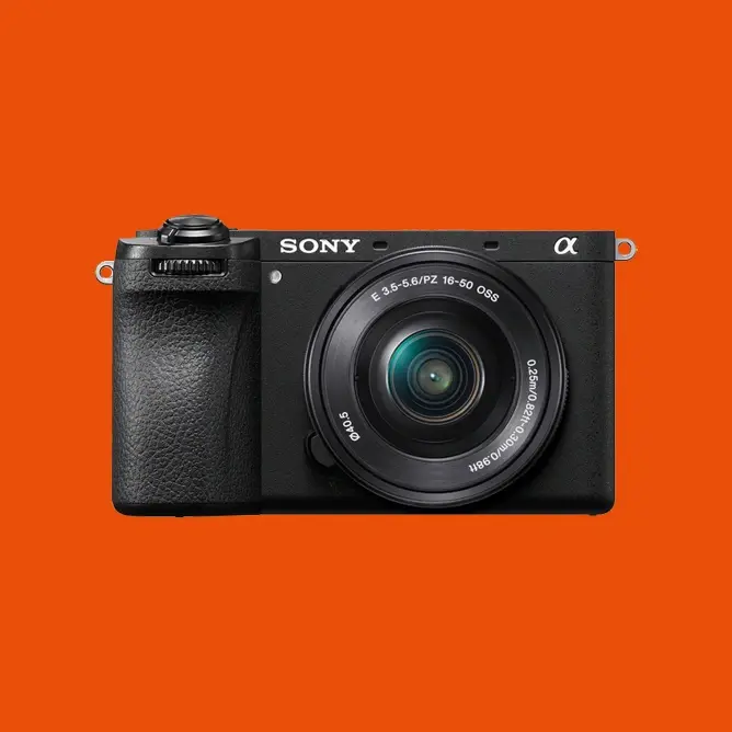 Sony speilløst kamera med sort kropp og linse, plassert mot en oransje bakgrunn