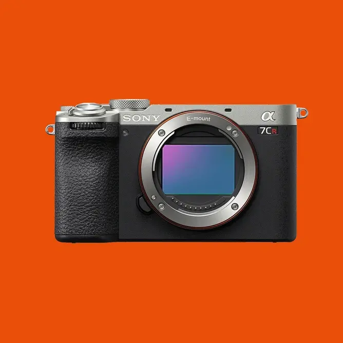 Sony Alpha 7C R speilløst kamera uten objektiv, svart og sølvfarget, mot oransje bakgrunn