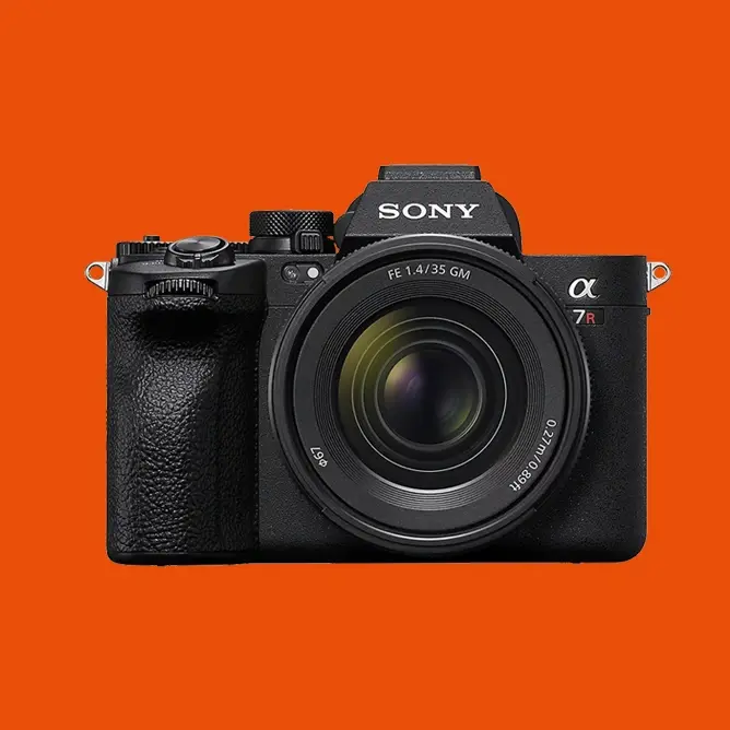 Sony speilløst kamera med sort kamerahus og 35mm f/1.4 GM-objektiv mot oransje bakgrunn