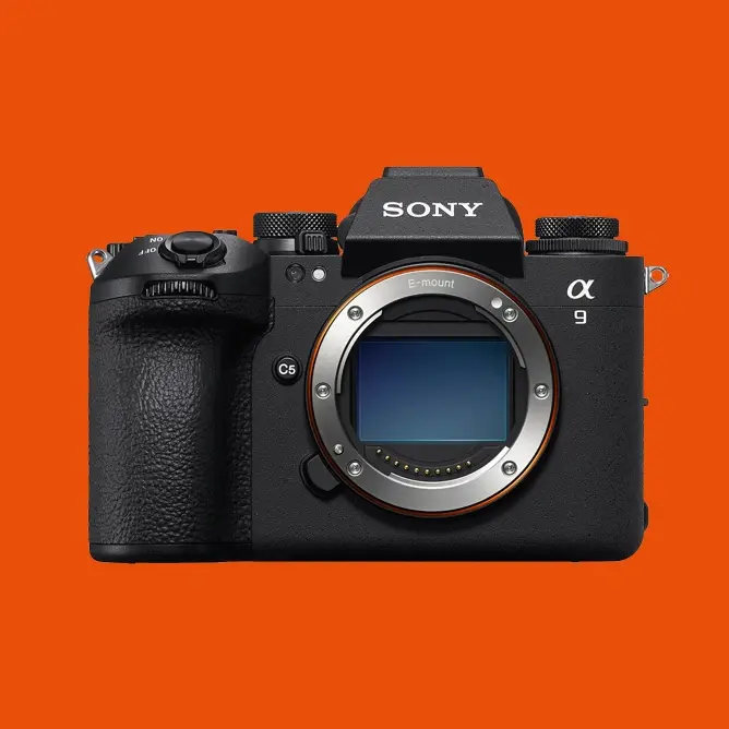 Svart Sony α9 speilløst kamera mot en oransje bakgrunn