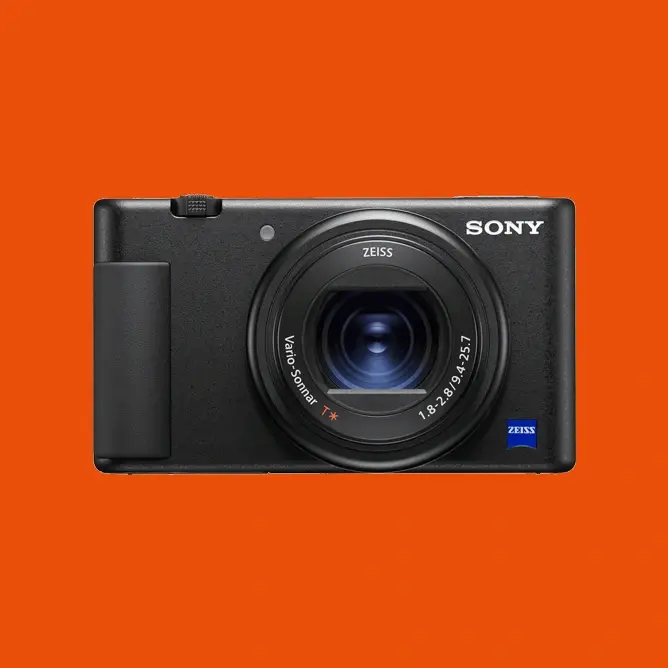 Sony digitalkamera med Zeiss Vario-Sonnar-objektiv mot oransje bakgrunn