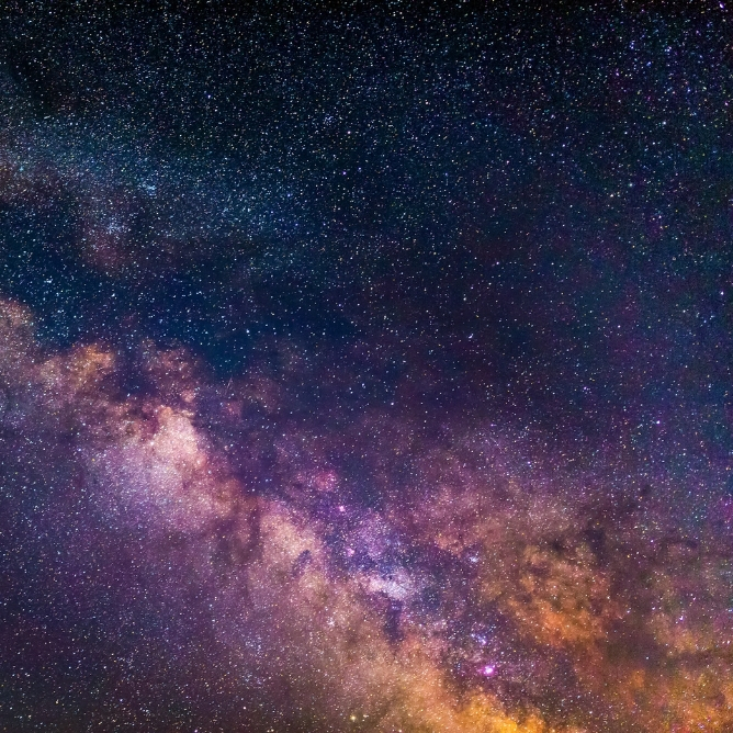 Stjernehimmel med et klart syn på Melkeveien, fylt med lilla, rosa og gyldne nyanser