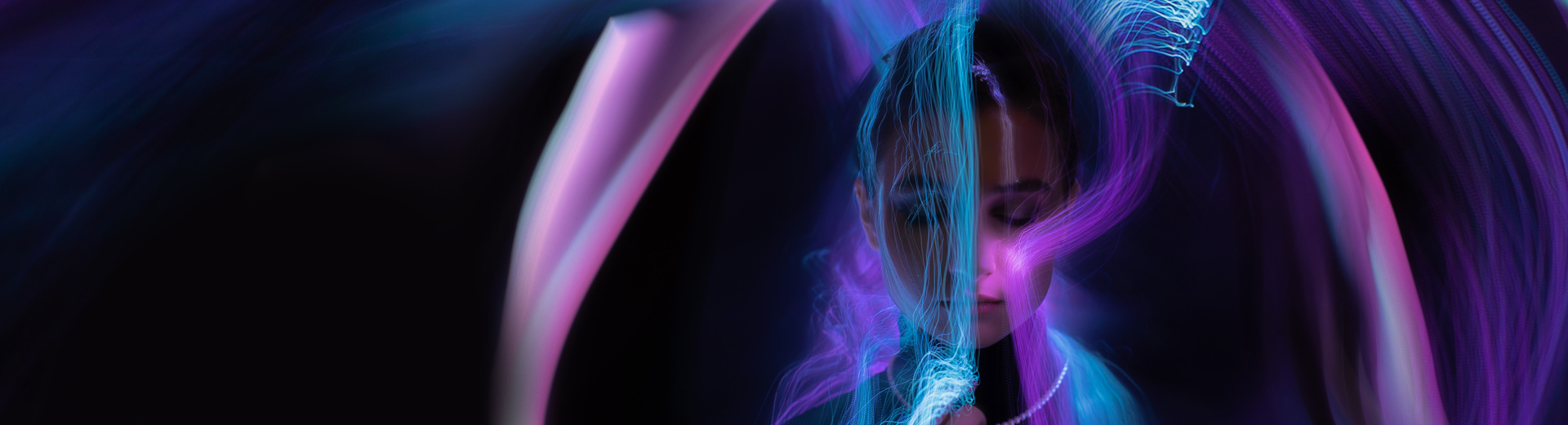 Abstrakte lysstråler i lilla og blått sveiper dynamisk over en mørk bakgrunn