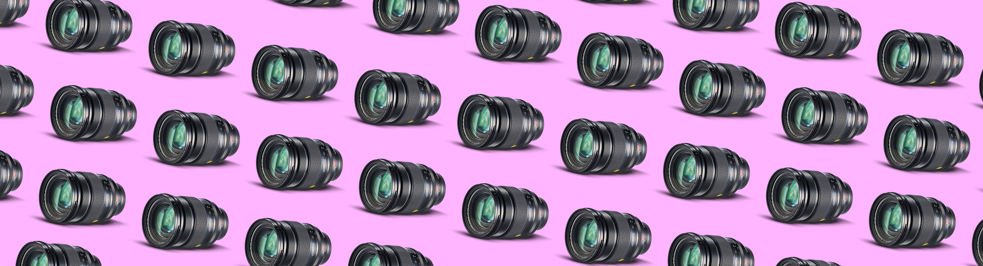 Gjentatte sorte kameralinser med grønne reflekser lagt mønsteraktig på rosa bakgrunn