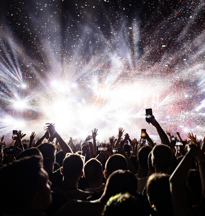 En festival med lys, konfetti og en jublende folkemengde som løfter hendene i begeistring En festival med lys, konfetti og en jublende folkemengde som løfter hendene i begeistring