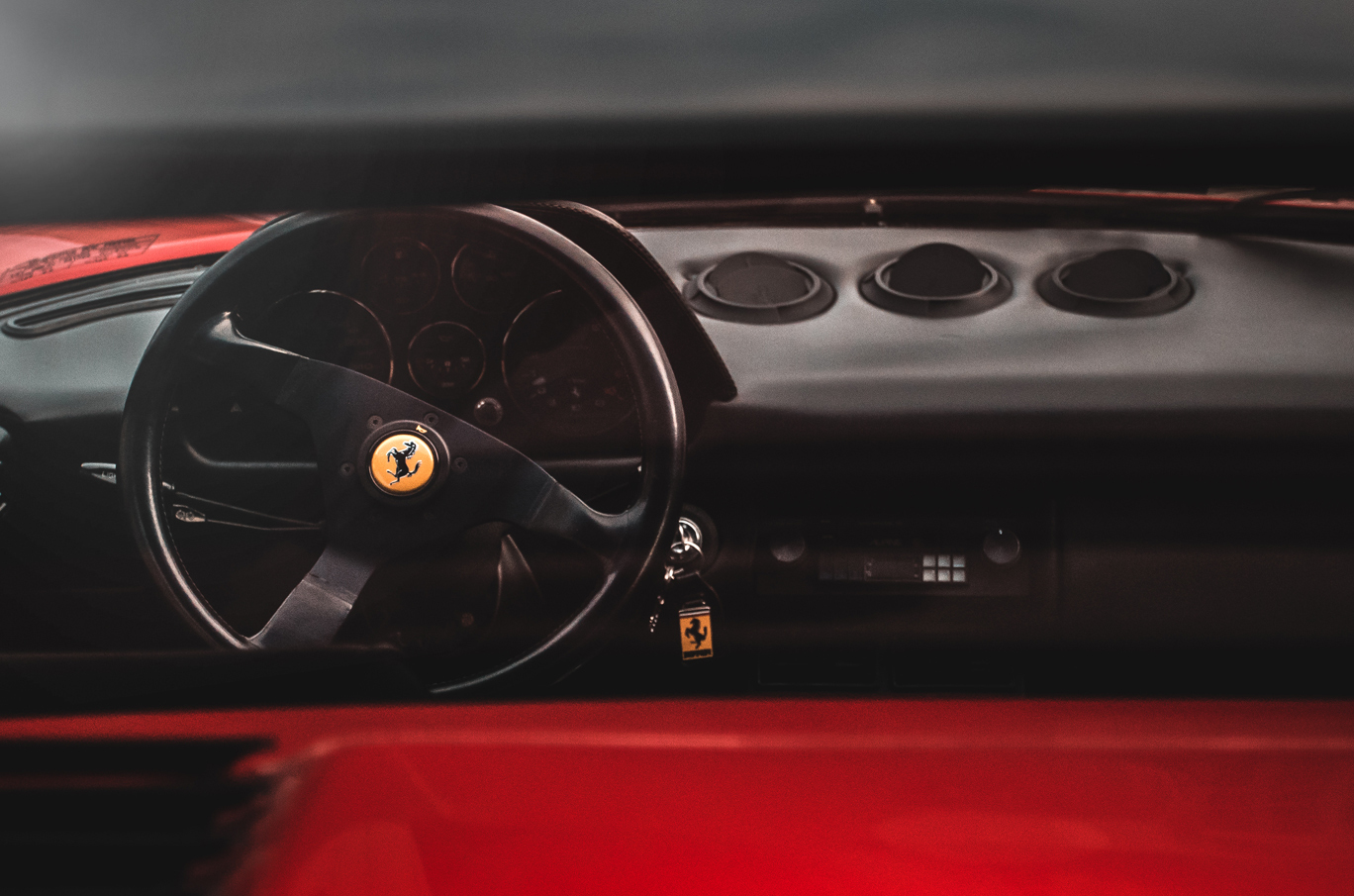 Ratt og interiør i en klassisk Ferrari med nøkkelring som viser Ferrari-logoen