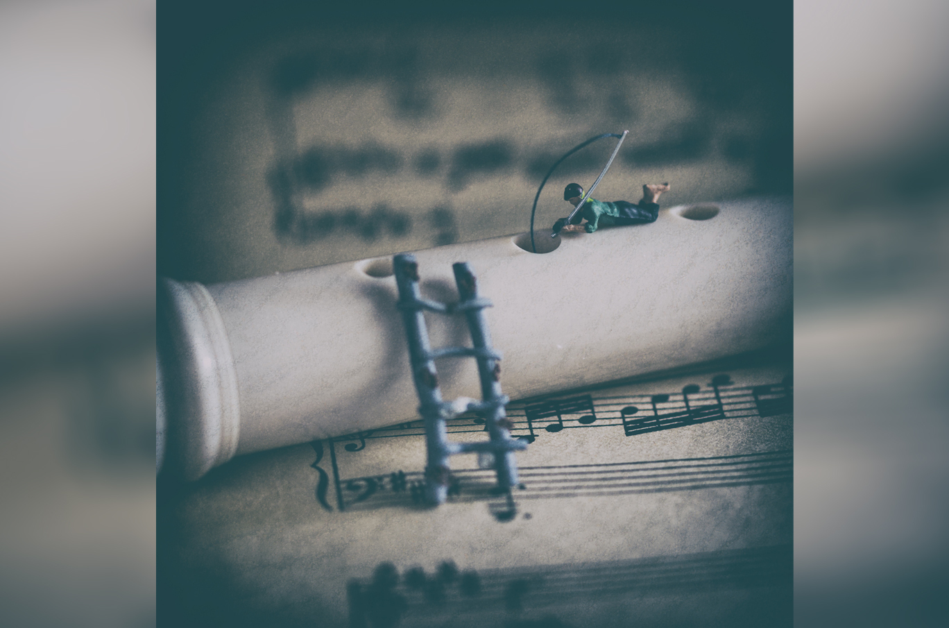 Miniatyrfigur som fisker fra en blokkfløyte plassert på et noteark med musikklinjer