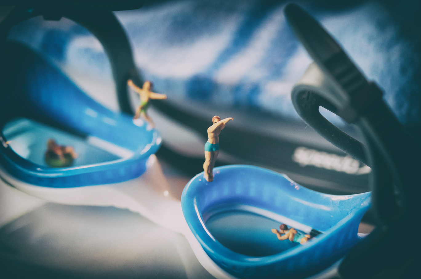 Miniatyrfigurer som står og dykker på kanten av blå svømmebriller