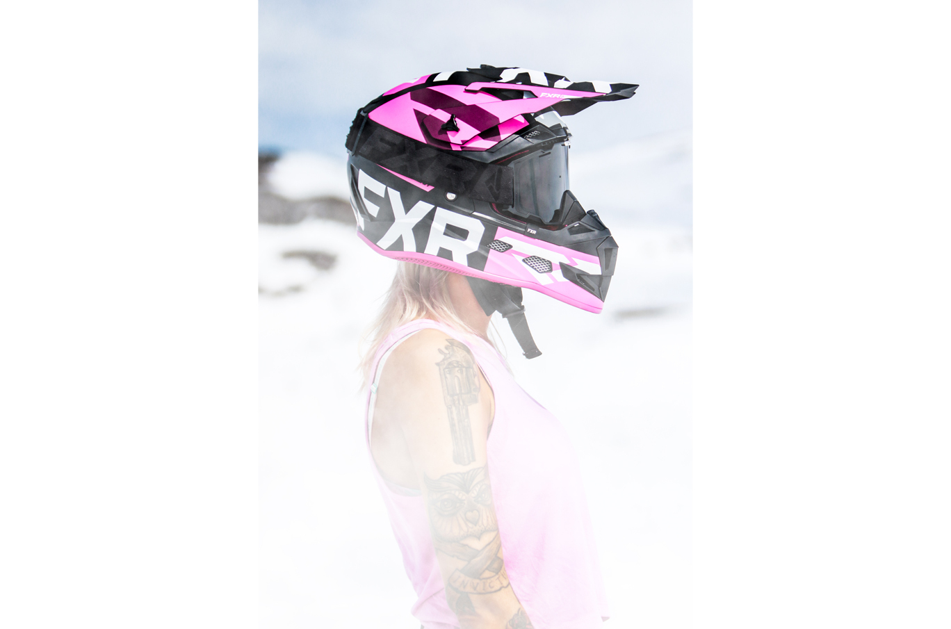 Person iført rosa motocrosshjelm og rosa tanktopp på en solrik vinterdag