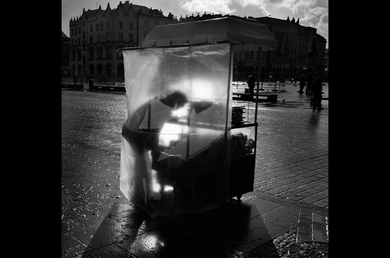 En person som arbeider inne i en gjennomsiktig plastbod med sollys som skinner gjennom den