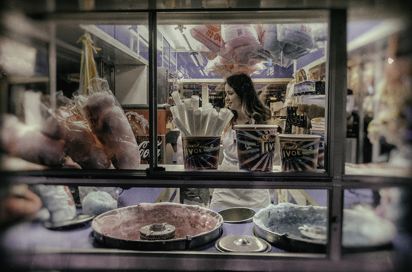 Sukkerspinnmaskin og boder med fargerike godterispann og poser med sukkerspinn