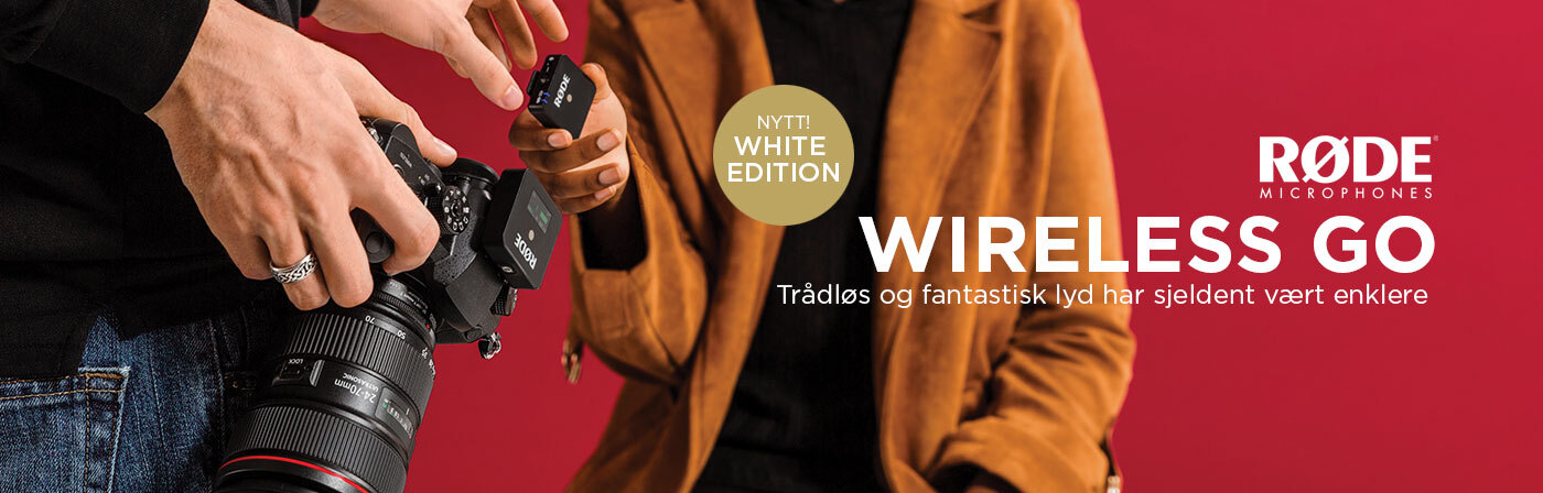 To personer holder en kamera og en trådløs mikrofon fra RØDE Wireless Go White Edition, mot en rød bakgrunn