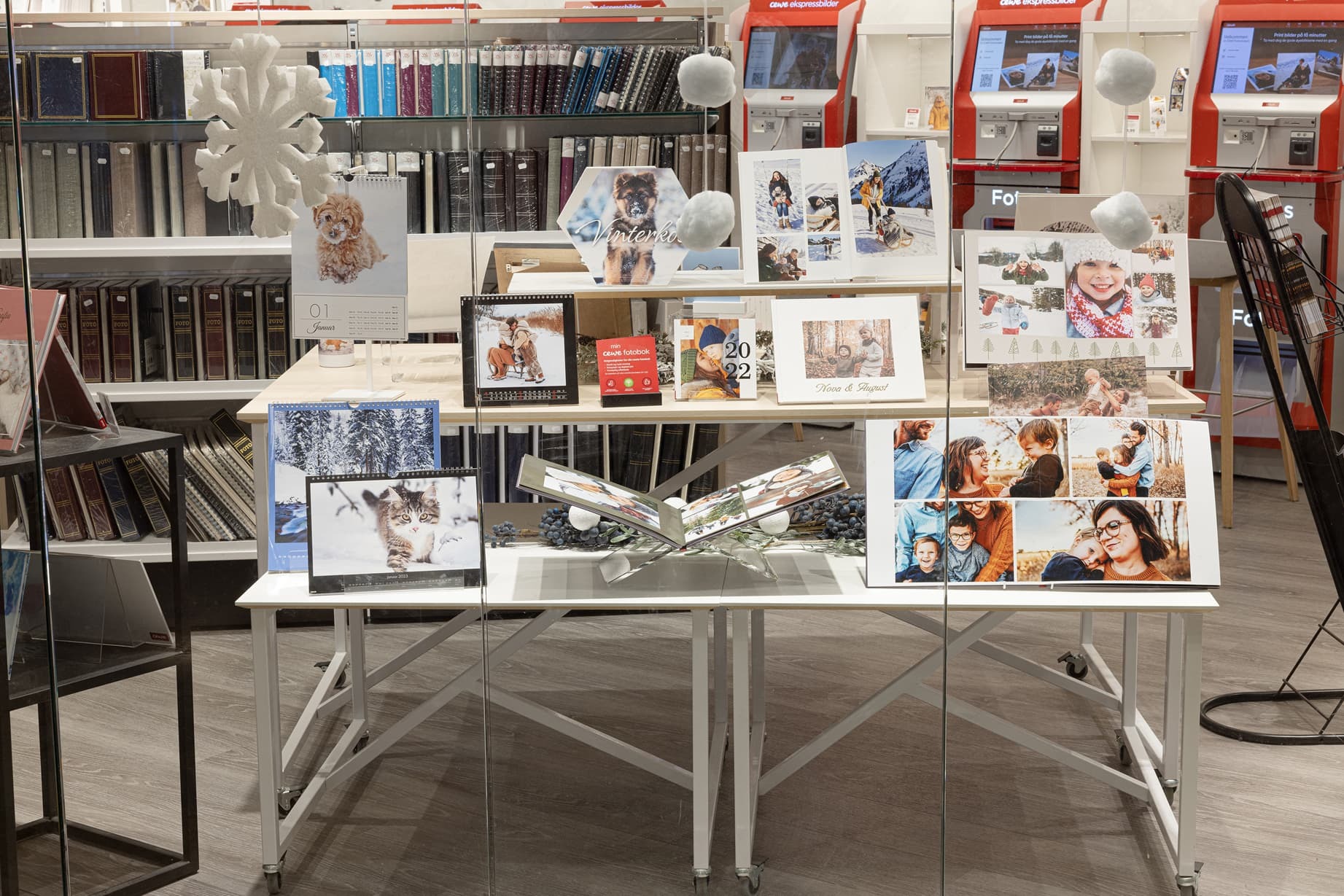 Utstillingsbord med fotokalendere og fotobøker dekorert med vinterlige og festlige elementer